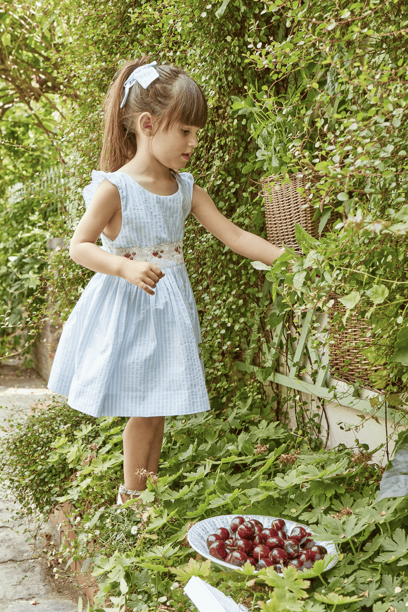 Bégonia, smocked dress with ruffled straps on back, in Blue and white seersucker stripes