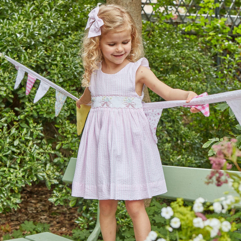 Bégonia, smocked dress with ruffled straps on back, in Pink and white seersucker stripes