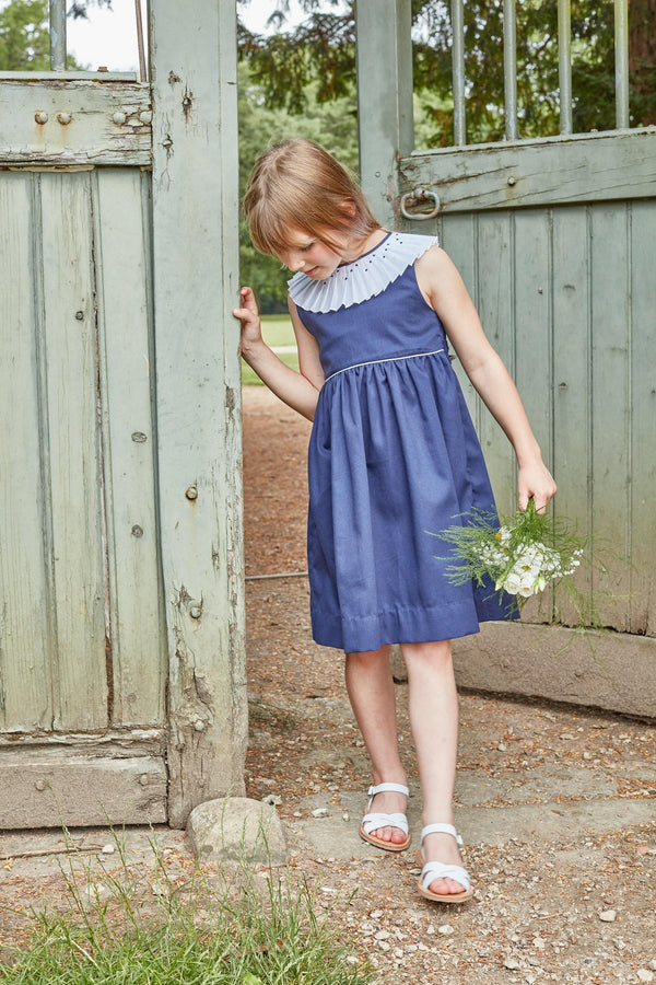 Aloé, robe sans manche avec un passepoil blanc à la taille, col plissé et brodé, en piqué de coton marine - sleeveless dress with white piping at the waist, pleated and embroidered collar, in navy cotton piqué