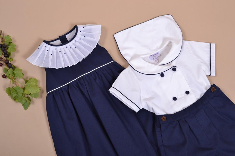 Aloé, robe sans manche avec un passepoil blanc à la taille, col plissé et brodé, en piqué de coton marine - sleeveless dress with white piping at the waist, pleated and embroidered collar, in navy cotton piqué