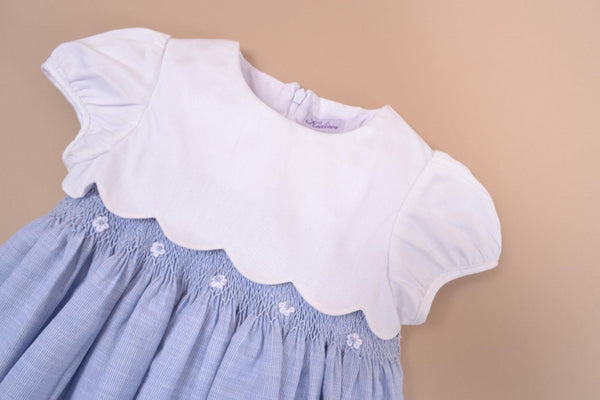 Festony, balloon-sleeved dress top in scalloped white cotton piqué, smocked bottom and embroidered at the waist in 1mm blue and white stripes