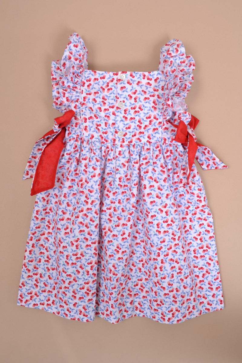 Kalanchoé, robe manches volants, encolure carrée, nœuds contrastés sur les côtés, en imprimé cerises bleues et rouges