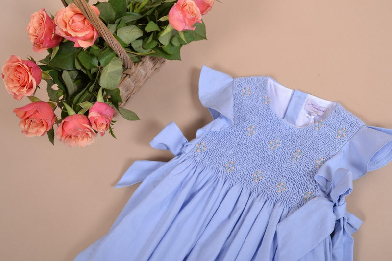 Lewisia, robe manches papillons, col rond, buste entièrement smocké, nœuds bicolores sur les côtés, en coton bio bleuet - dress with butterfly sleeves, round neck, fully smocked bust, bows on the sides, in cornflower blue organic cotton