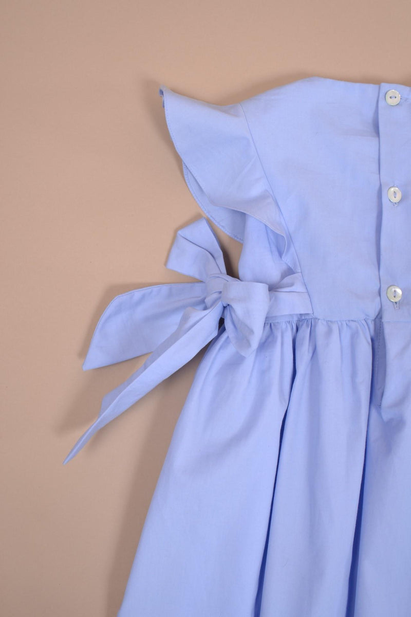 Lewisia, robe manches papillons, col rond, buste entièrement smocké, nœuds bicolores sur les côtés, en coton bio bleuet - dress with butterfly sleeves, round neck, fully smocked bust, bows on the sides, in cornflower blue organic cotton